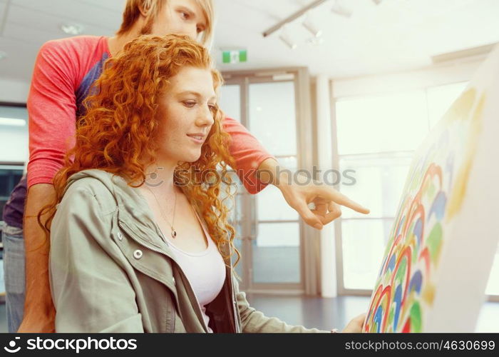 Young caucasian couple standing in a gallery and contemplating artwork. Young caucasian couple standing in a gallery and contemplating abstract artwork