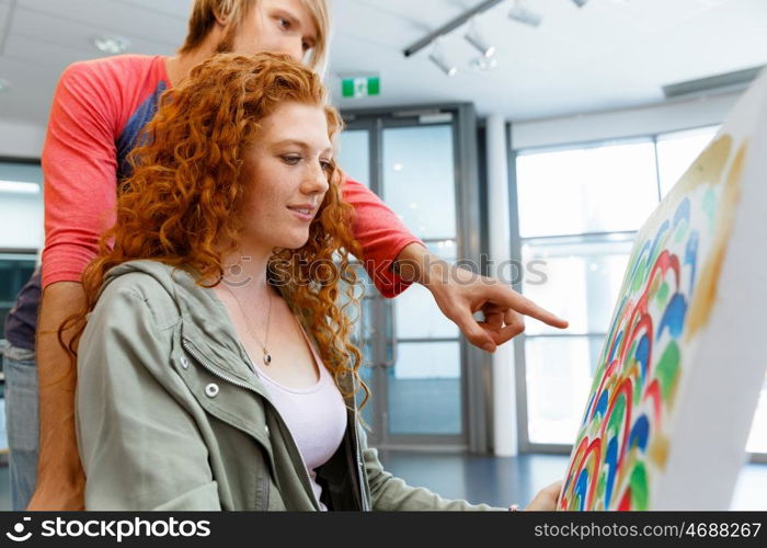 Young caucasian couple standing in a gallery and contemplating artwork. Young caucasian couple standing in a gallery and contemplating abstract artwork