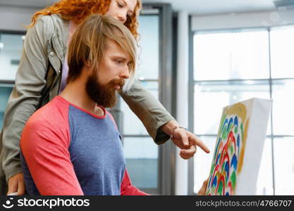 Young caucasian couple standing in a gallery and contemplating artwork. Young caucasian couple standing in a gallery and contemplating abstract artwork