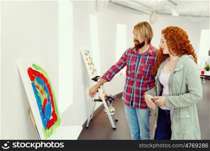 Young caucasian couple standing in a gallery and contemplating artwork. Young caucasian couple standing in a gallery and contemplating abstract artwork