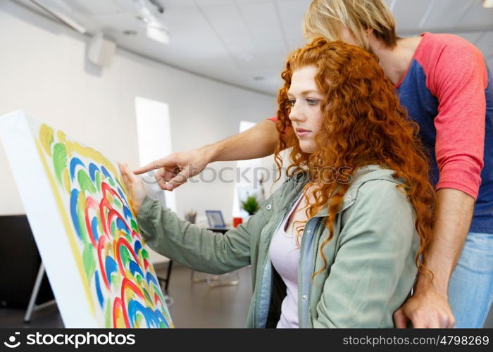 Young caucasian couple standing in a gallery and contemplating artwork. Young caucasian couple standing in a gallery and contemplating abstract artwork