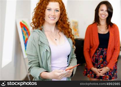 Young caucasian couple standing in a gallery and contemplating artwork. two young women in a gallery and contemplating abstract artwork