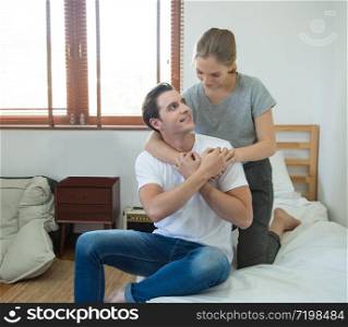 Young caucasian couple woman hug man back on bed with love on bed in bedroom at home.. asian woman hug man from back on bed at home
