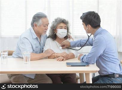 Young caucasian doctor man talking result of examination on file folder to senior elderly old retirement asian woman with old man take care her beside.healthcare and medical concept.