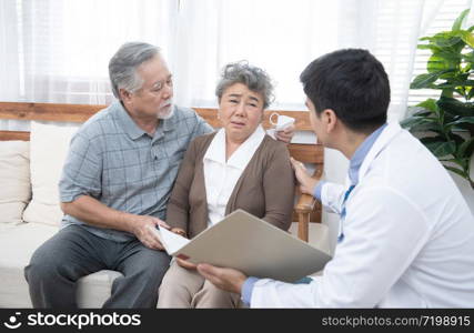 Young caucasian doctor man talking result of examination on tablet to senior elderly old retirement asian woman with old man take care her beside.healthcare and medical concept.