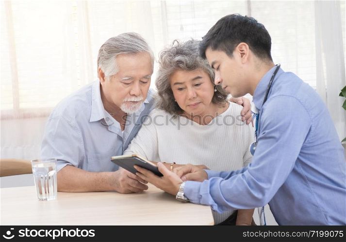 Young caucasian doctor man talking result of examination on tablet to senior elderly old retirement asian woman with old man take care her beside.healthcare and medical concept.