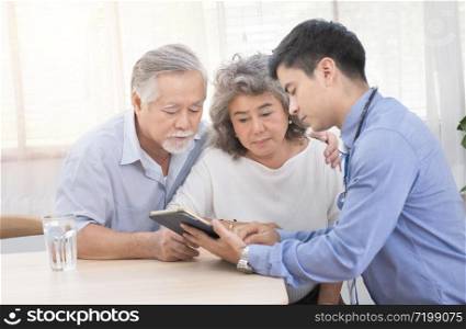 Young caucasian doctor man talking result of examination on tablet to senior elderly old retirement asian woman with old man take care her beside.healthcare and medical concept.