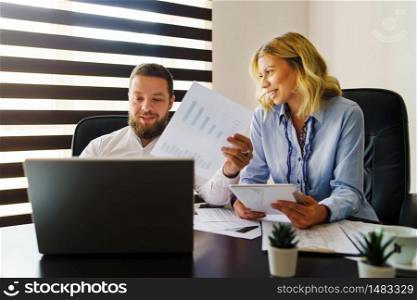 Young caucasian man and woman at office looking project documents