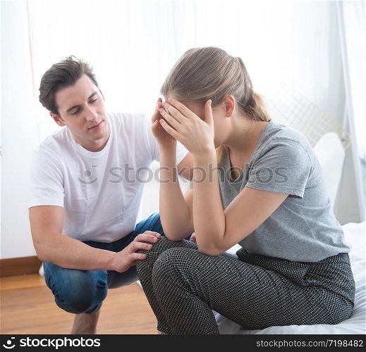 Young caucasian man comforting sad woman and sit on begin bedroom. sad man sit in bed and thinking with man comfort