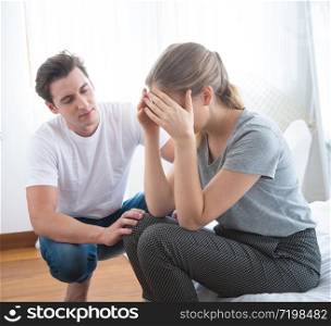 Young caucasian man comforting sad woman and sit on begin bedroom. sad man sit in bed and thinking with man comfort