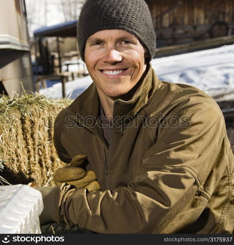 Young Caucasian man outdoors in rural setting smiling at viewer.