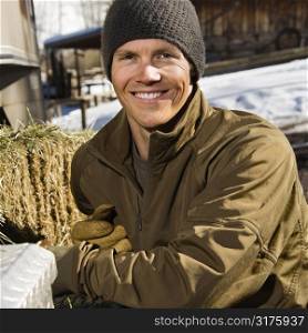 Young Caucasian man outdoors in rural setting smiling at viewer.
