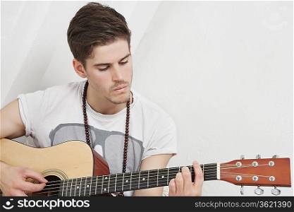 Young Caucasian man playing guitar