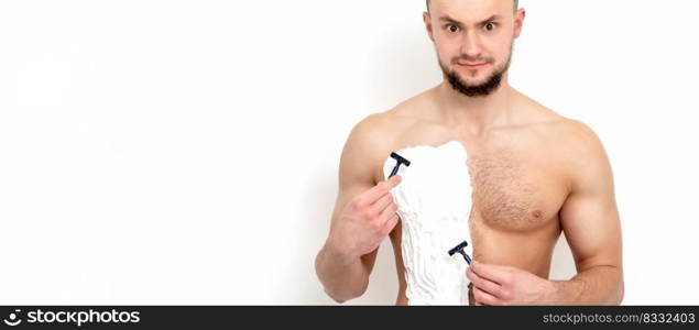 Young caucasian man with beard holds razor shaves his chest with white shaving foam on white background. Man shaving his torso. Young man shaving his chest