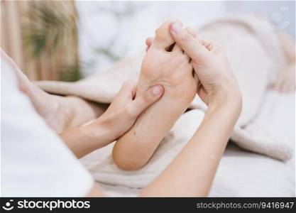 young caucasian physiotherapist Woman giving a feet massage to female patient in clinic. Physiotherapy and body care concept