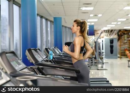 Young caucasian sporty Woman On Running Machine In Gym. Young sporty Woman On Running Machine In Gym