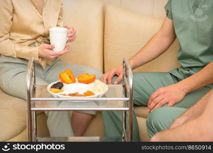 Young caucasian woman consulting with two masseurs during tea with dried fruit in the massage spa. Young caucasian woman consulting with two masseurs during tea with dried fruit in the massage spa.