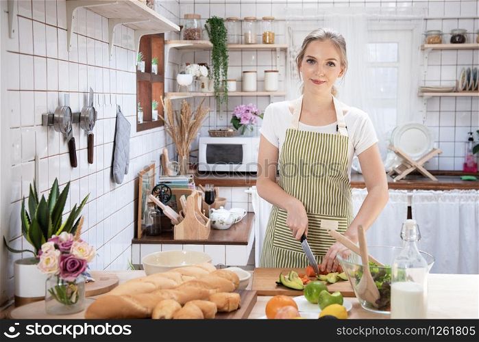 Young caucasian woman cooking food in the kitchen. Healthy food and dieting concept. healthy lifestyle.Teenager housewife cooking at home.