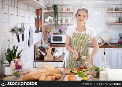 Young caucasian woman cooking food in the kitchen. Healthy food and dieting concept. healthy lifestyle.Teenager housewife cooking at home.
