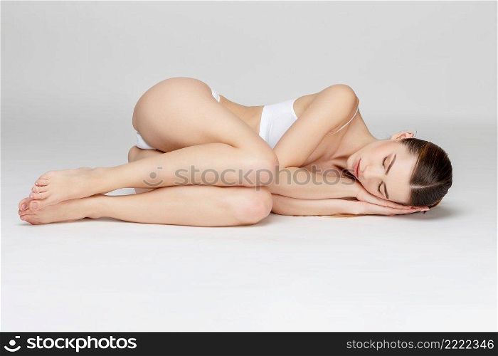 Young caucasian woman in studio on gray background. Young woman on gray background
