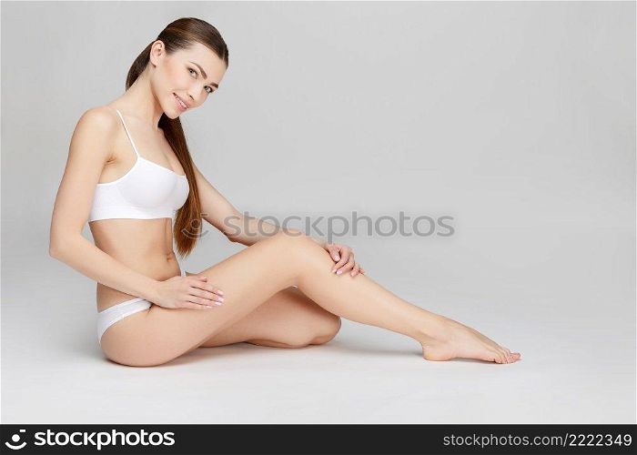 Young caucasian woman in studio on gray background. Young woman on gray background