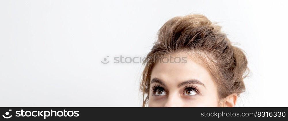 Young caucasian woman looking up on white background. Half face of woman looking upwards, copy space. Woman looking up on white background