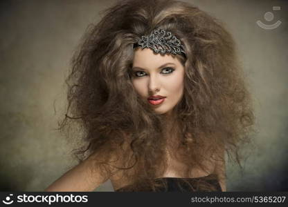 young caucasian woman posing in fashion portrait with voluminous curly hair-style, glitter accessory in the hair and cute make-up