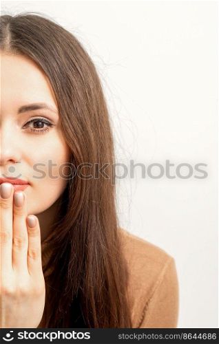 Young caucasian woman posing with fashion beige nails and sensual lips in studio. Young caucasian woman posing with fashion beige nails and sensual lips in studio.