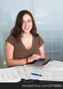Young caucasian woman preparing tax form 1040 for tax year 2012 with receipts and calculator