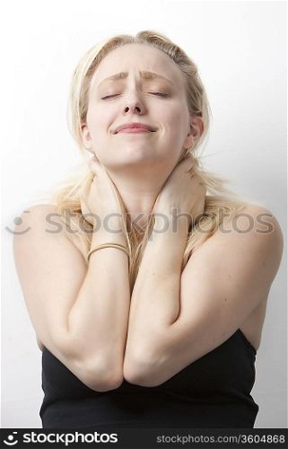 Young Caucasian woman suffering from neckache standing against white background