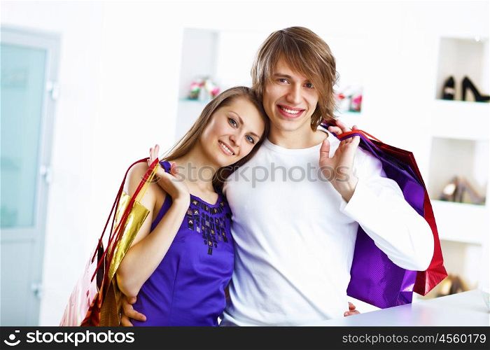 Young caucausian couple with bags doing shopping together