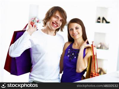Young caucausian couple with bags doing shopping together