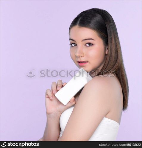 Young charming  girl with natural beauty, perfect smooth skin hold lotion, cream, moisturizer tube. Beautiful  girl show skincare product smiling on isolated background.. Young charming  girl with natural beauty hold lotion tube.l