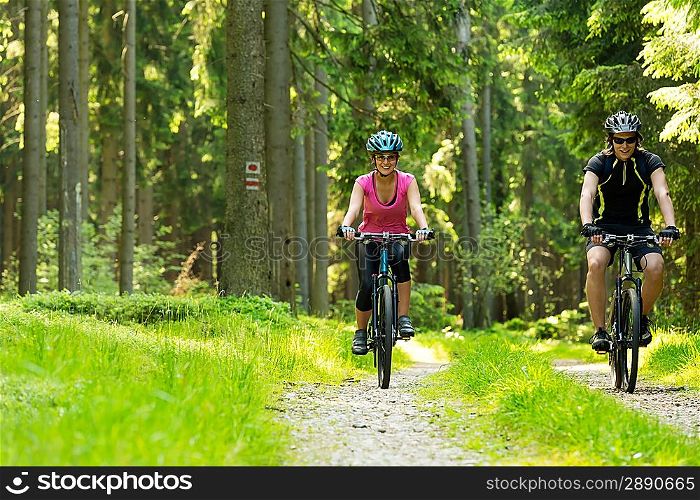 Young cheerful biker couple in woods