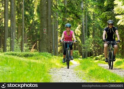 Young cheerful biker couple in woods