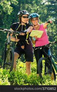 Young cheerful bikers checking the map sunny day in nature