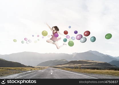 Young cheerful lady in red dress jumping high