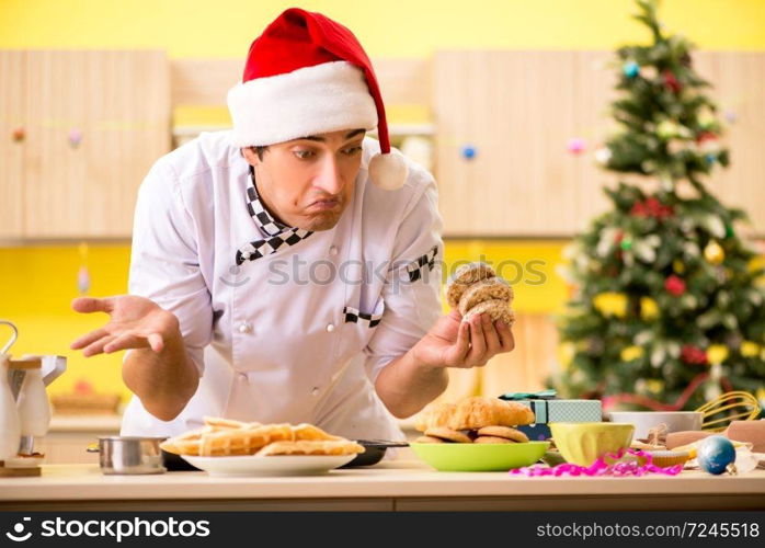 Young chef husband working in kitchen at Christmas eve 