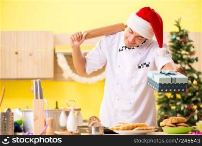 Young chef husband working in kitchen at Christmas eve 