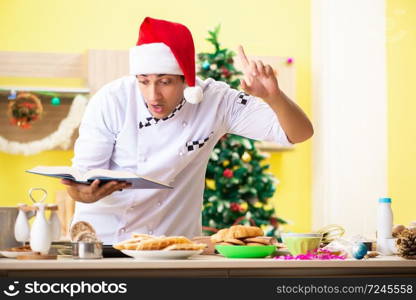 Young chef husband working in kitchen at Christmas eve 