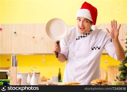 Young chef husband working in kitchen at Christmas eve . The young chef husband working in kitchen at christmas eve 
