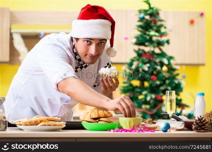 Young chef husband working in kitchen at Christmas eve 