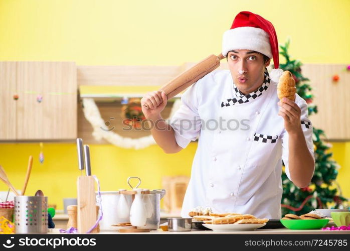 Young chef husband working in kitchen at Christmas eve 