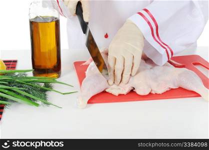 young chef in uniform prepares chicken. Isolated on white background