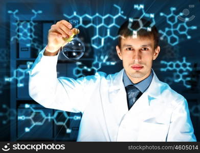 Young chemist in white uniform working in laboratory