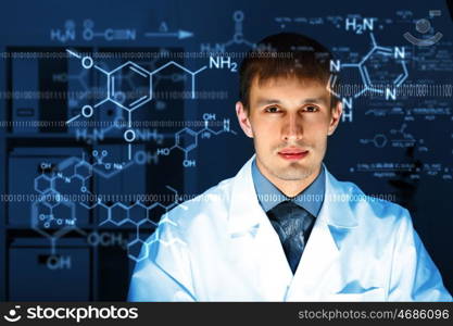 Young chemist in white uniform working in laboratory