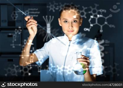 Young chemist in white uniform working in laboratory