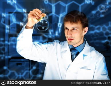 Young chemist in white uniform working in laboratory