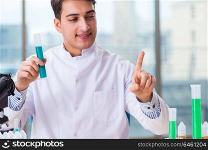 Young chemist pressing virtual buttons in lab