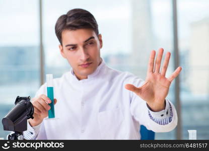 Young chemist pressing virtual buttons in lab